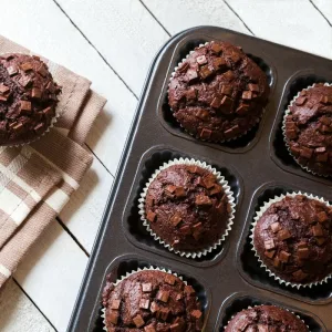 bolinho de chocolate: : Bolinhos de chocolate frescos e macios dispostos em uma assadeira, com gotas de chocolate de por cima.