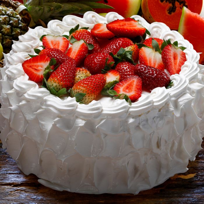 receita de bolo de aniversário simples caseiro: bolo coberto com chantilly e morangos
