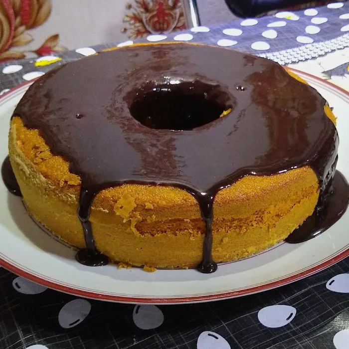 como fazer bolo de cenoura: delicioso bolo de cenoura com calda de chocolate em uma prato.