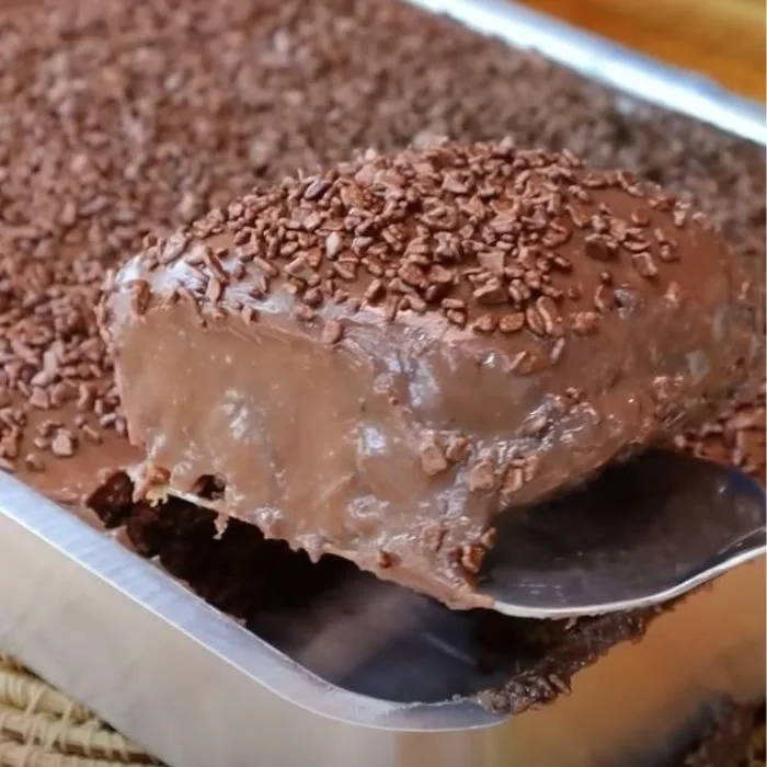 como fazer bolo de chocolate: assadeira com bolo e uma fatia cortada