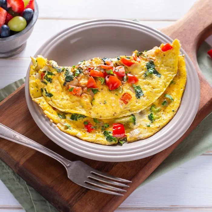 receita de omelete: prato com omelete pronta com tomates e