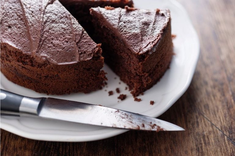 receita de: bolo de chocolate em um prato com uma faca ao lado.