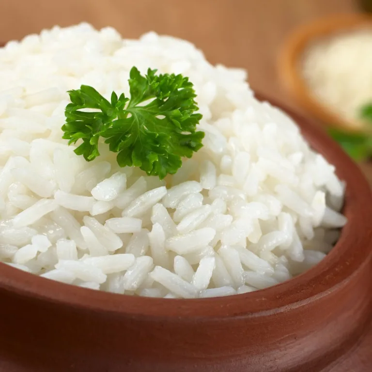 como fazer arroz: tigela marron com arroz dentro e uma folha de salsinha para decorar
