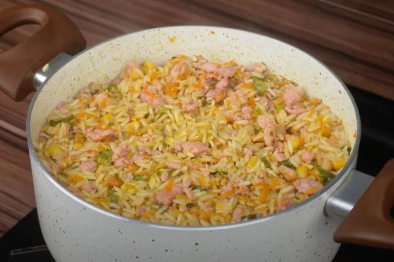 arroz em uma panela com linguiça, cenoura, milho e mais temperos pronto para ser servido.