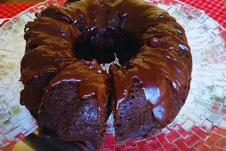 bolo de banana com cacau com uma cobertura de chocolate sendo fatiado para servir.