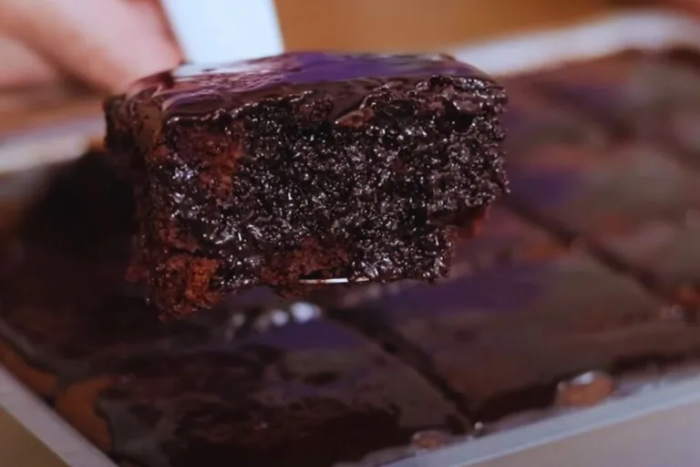 bolo de chocolate sem batedeira: uma fatia de bolo sendo retirada da assadeira.