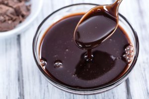 como fazer calda de chocolate: calda cremosa de chocolate em uma tigela pequena pronta para ser utilizada.