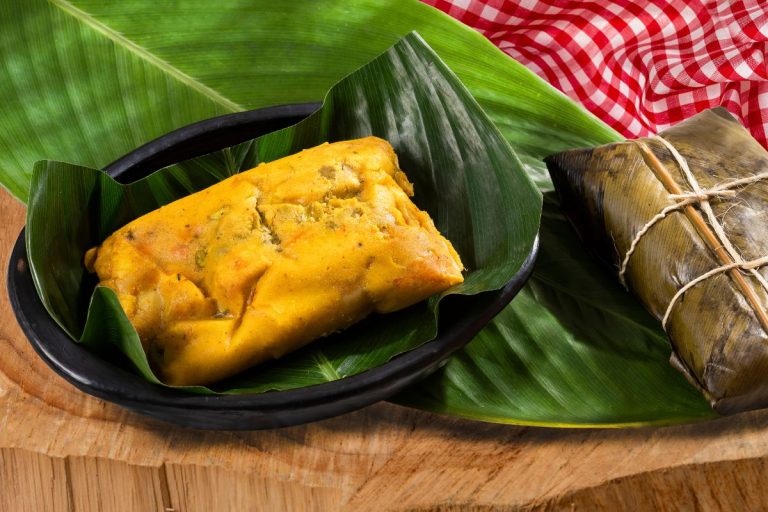 pamonha exótica de coco e queijo: pamonha assada e pronta sobre uma folha de bananeira.