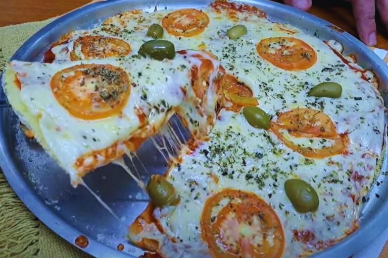deliciosa pizza de tapioca com recheio de mussarela e tomates.