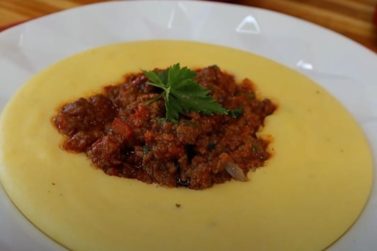 receita de polenta: prato com deliciosa polenta cremosa e carne moída com molho vermelho.