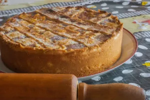 torta de banana em cima da mesa com rolo de macarrão ao lado.