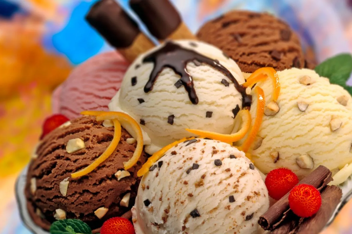 várias bolas de sorvete de sabores diversos com confeitos e calda.