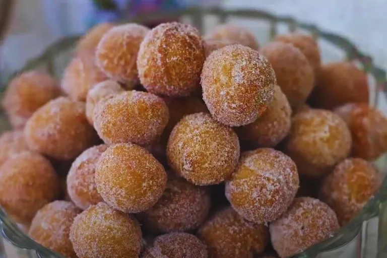 receita de bolinho de chuva: vários bolinhos açucarados em um vasilha prontos para serem servidos.