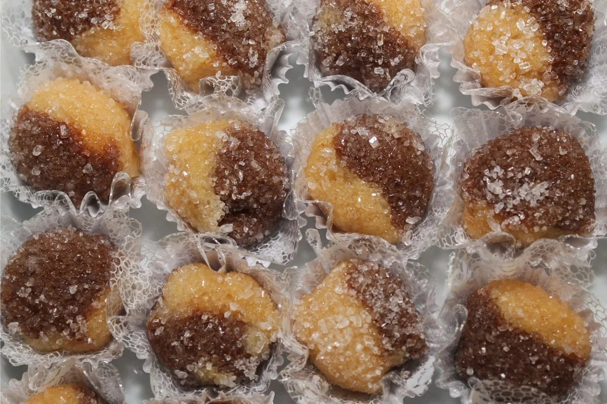 vários brigadeiros casadinhos em forminhas brancas.