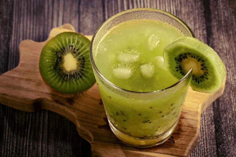 Caipirinha de kiwi em um copo decorado com kiwi e gelo