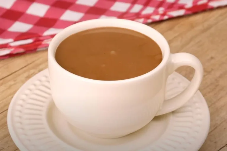xícara branca com chocolate quente com creme de leite