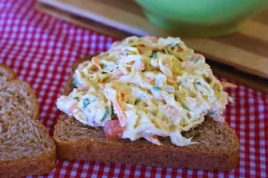 receita de lanche da tarde saudavel: fatia de pãp de forma integral com patê de frango desfiado com cenoura, salsinha, cebolinha, milho e maionese.