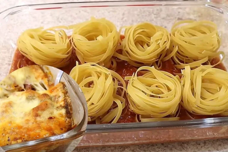 molho de tomates e massas cruas de macarrão por cima em uma travessa durante o processo de preparo do macarrão de forno.