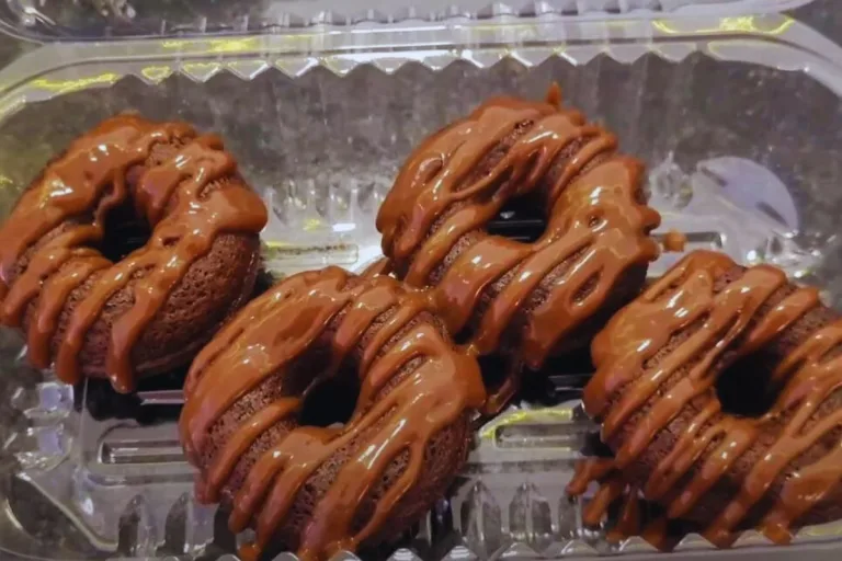 mini cake donuts massa de chocolate em uma embalagem decorado com chocolate derretido.