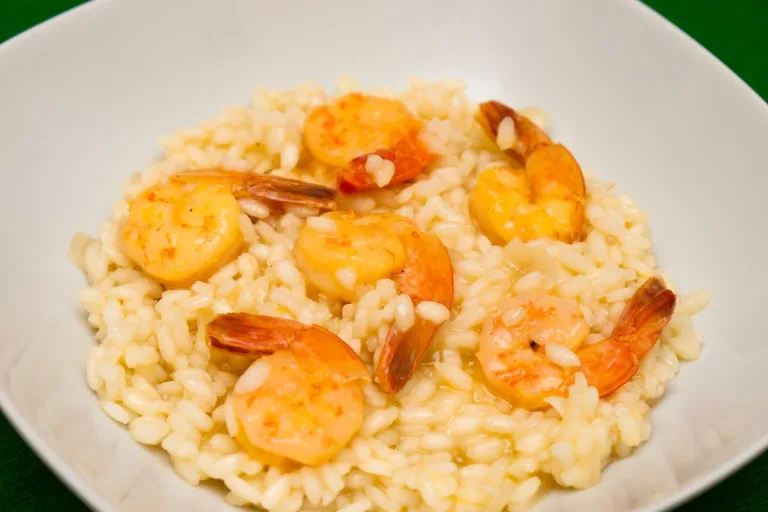 risoto de camarão em um prato branco.