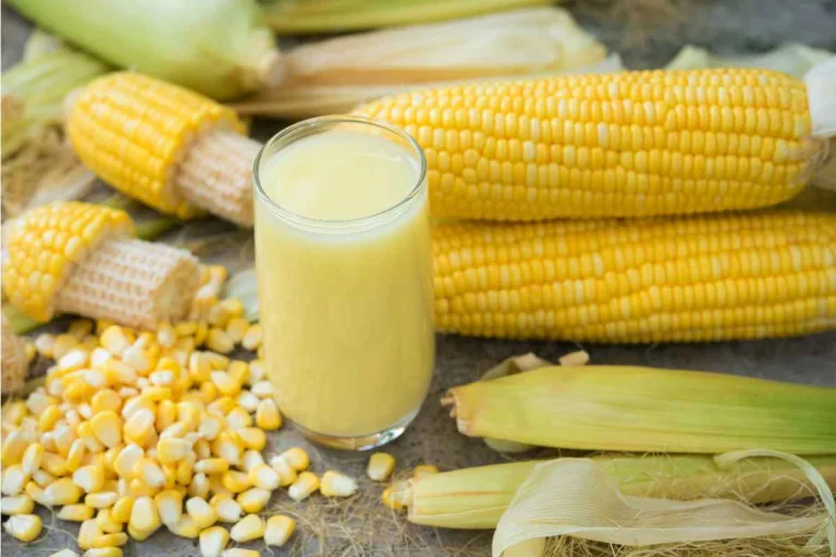 copo de suco de milho verde com espigas de milho ao redor.