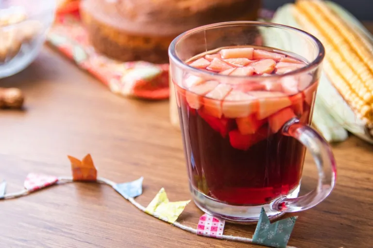 vinho quente numa xícara e ao redor decoração de festa junina